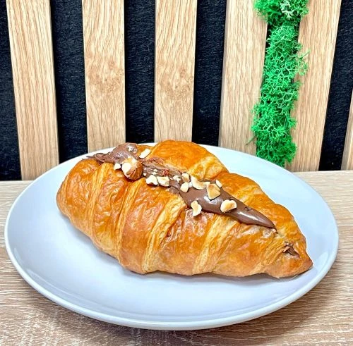 Croissant plněn&yacute; nutellou sypan&yacute; sekan&yacute;mi l&iacute;skov&yacute;mi oř&iacute;&scaron;ky